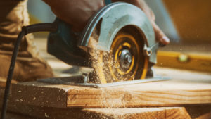 A circular saw cutting through a wooden plank