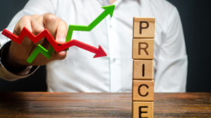Man holding red and green arrows next to blocks spelling out "price".