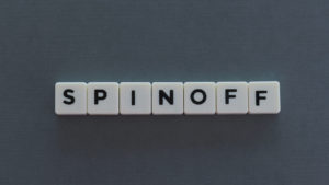 The word spinoff spelled out on plastic cubes