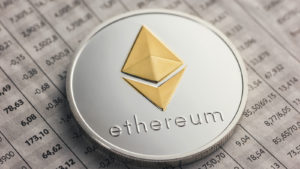 A coin with the Ethreum logo on top of a financial document representing Is Ethereum a Buy.