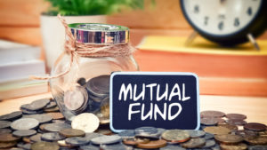 A jar of coins with a sign that says mutual fund