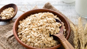 otly stock Rolled oats or oat flakes in bowl with wooden spoons. VEGAN stocks