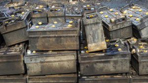 A pile of used industrial batteries stacked on top of each other.