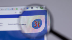 The logo for the holding company 3i is seen through a magnifying glass on the company's website.