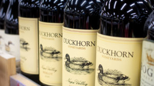 Several bottles of Duckhorn Vineyards merlot are lined up in a row.