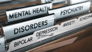 A row of file folders with labels reading "mental health," "psychiatry," "disorders", "bipolar," "depression," "anxiety" and "schizophrenia".