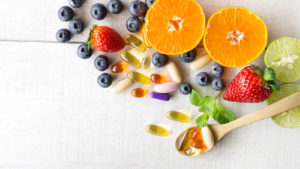 vitamins sitting on a surface with a variety of fruits