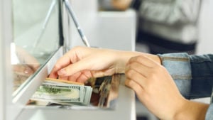 A customer makes a transaction at a bank representing FHN stock news for today.