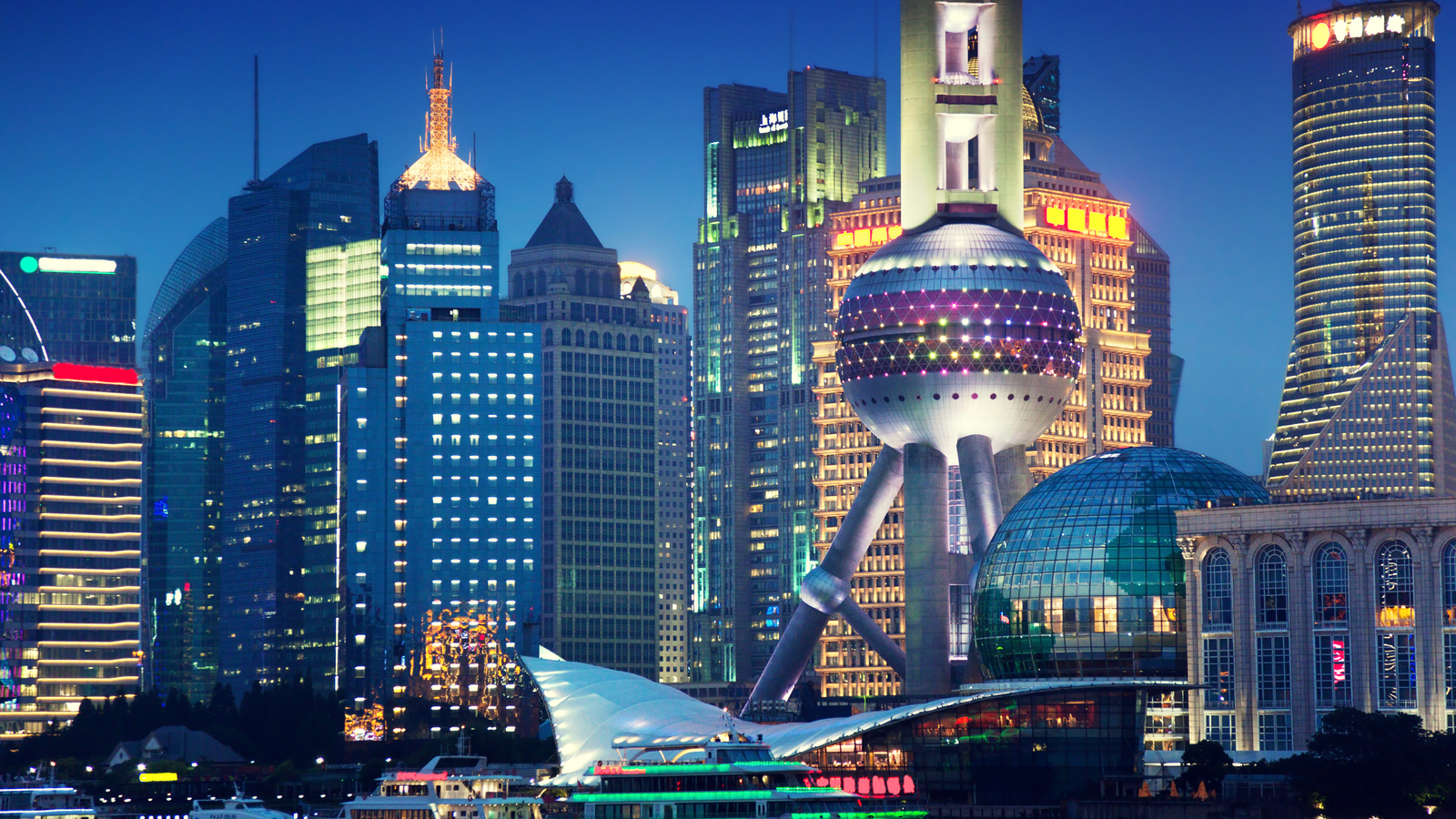 A photo of the Shanghai skyline at night featuring the Oriental Pearl Tower.