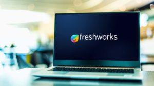 The logo for Freshworks (FRSH) is displayed on a laptop screen.