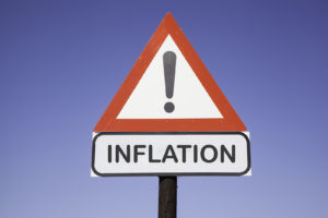 Road sign with black exclamation mark warning about inflation