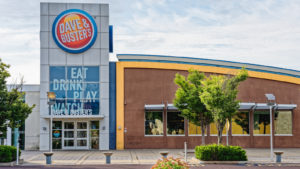 The storefront of a Dave and Busters location at a mall is seen during daytime.