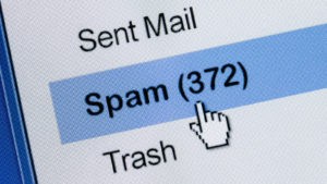 A close-up photo of a computer screen displaying a spam folder in an email account.