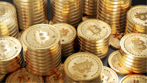 Piles of gold Bitcoin tokens stacked together.