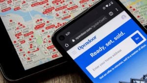 The Opendoor website is open on a smartphone that is resting on top of a map. Opendoor stock.