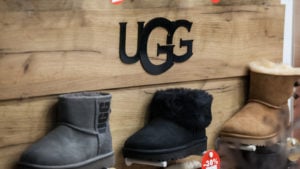 DECK stock: a display of three UGG boots of various colors in a shop with the logo displayed above them