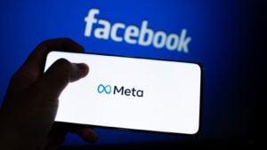 The META stock logo is displayed on a device screen. Meta is Facebook's new company name.