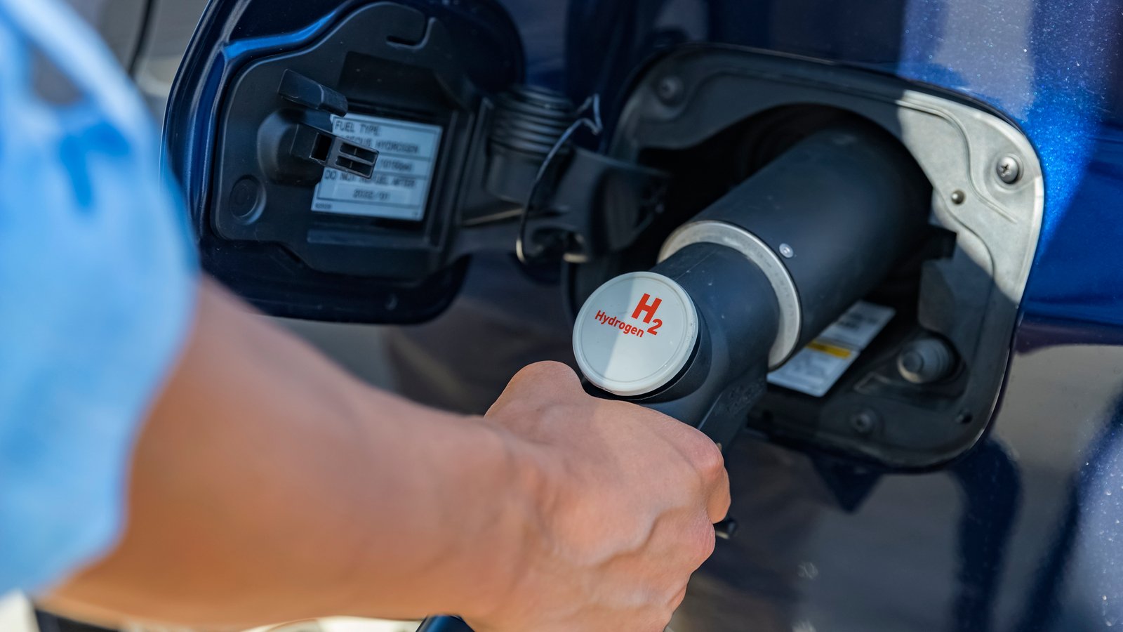 A person refueling a hydrogen car representing Hyzon Motors (HYZN) stock.