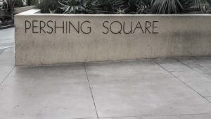 A Pershing Square sign on a cement wall.