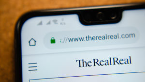 REAL 株式を表すスマートフォンの RealReal Web サイト。