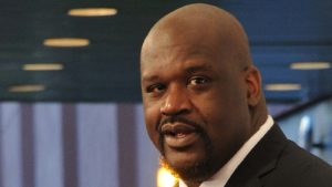 A close-up shot of Shaquille O'Neal in front of a blue background.