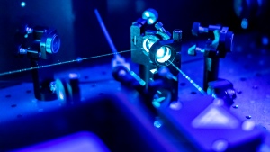 a blue laser and microscope representing LASE stock.