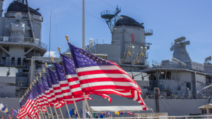 A U.S. Navy vessel with American flags waving in front of it representing MIND stock.