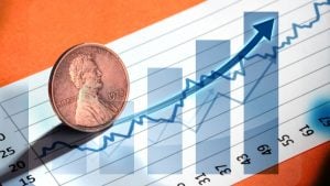A concept image of a penny sitting on a stock chart