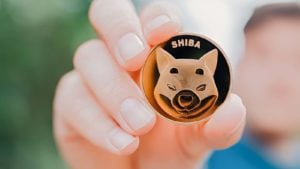 A hand holds a Shiba Inu (SHIB) concept crypto token.