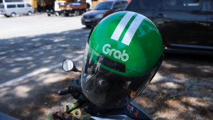 Motorcycle helmet with Grab logo on a motorcycle parked on the side of the road