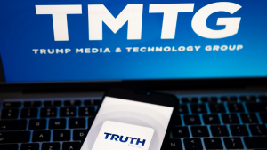 Truth Social app logo seen on the smartphone and blurred TMTG logo on the laptop
