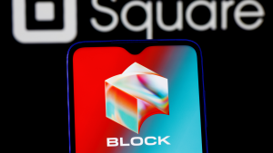 The logo of Block (SQ) appears on a phone screen with the company's old name and logo, Square, visible behind the phone.