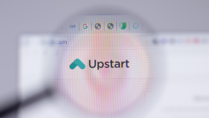 Upstart (UPST) の Web サイトは、会社のロゴに焦点を当てた虫眼鏡を通して表示されます。