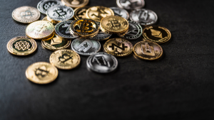 A photo of various crypto coins on a black surface representing Crypto News.