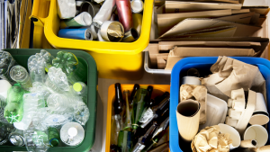 Bins are filled with various recyclibles, including cardboard, glass, and plastic