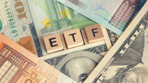 ETF investment index fund concept with wooden letters and lots of different currencies, ETF to buy