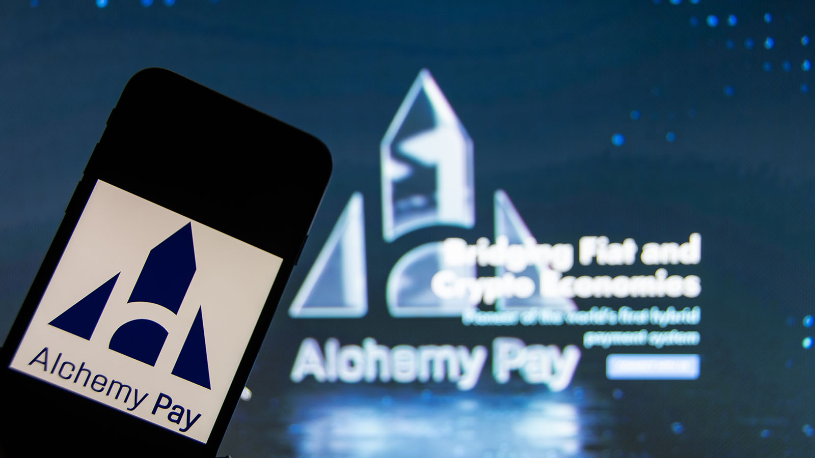 An iPhone with the Alchemy Pay (ACH) logo on the screen.