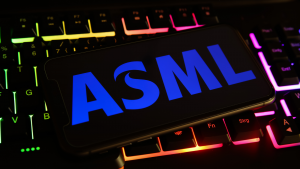 コンピューターのキーボードに ASML のロゴが表示された携帯電話の画面のクローズ アップ