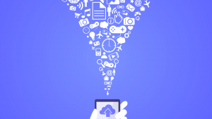 An image of a hand holding a phone with a cloud on the screen, icons above the phone; controller, music note, camera, plane, shopping cart, home, magnifying glass. Cloud computing stocks to buy