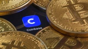 Stock COIN Logo Coinbase à l'écran avec des pièces Bitcoin