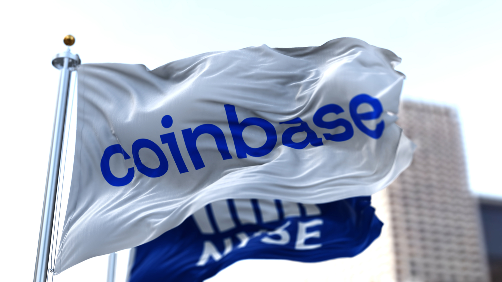 Flags of Coinbase and NYSE flying in the wind representing COIN Stock.