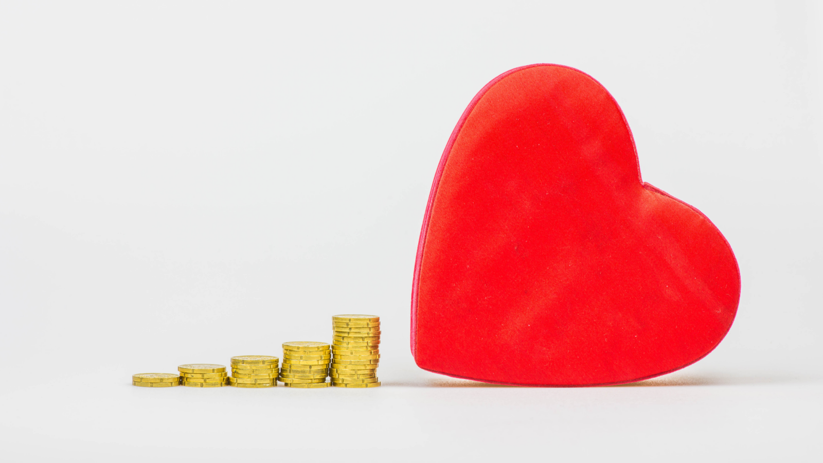 Stacks of gold coins increasing in amount lead up to a big red heart
