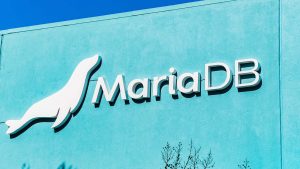 The logo for MariaDB displayed on a bright blue office building.