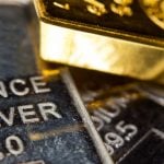 Close-up of a gold-ingot on top of a troy ounce silver and palladium bar. Precious metals. Gold, silver, palladium. materials stocks. resource shortage stocks