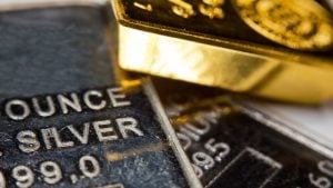 Close-up of a gold-ingot on top of a troy ounce silver and palladium bar. Precious metals. Gold, silver, palladium. materials stocks