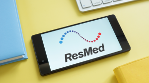 ResMed logo on a tablet on a yellow background. RMD stock. Stocks with Negative Analyst Sentiment