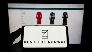 RENT stock: Person holding cellphone with logo of US e-commerce company Rent the Runway Inc on screen in front of business webpage