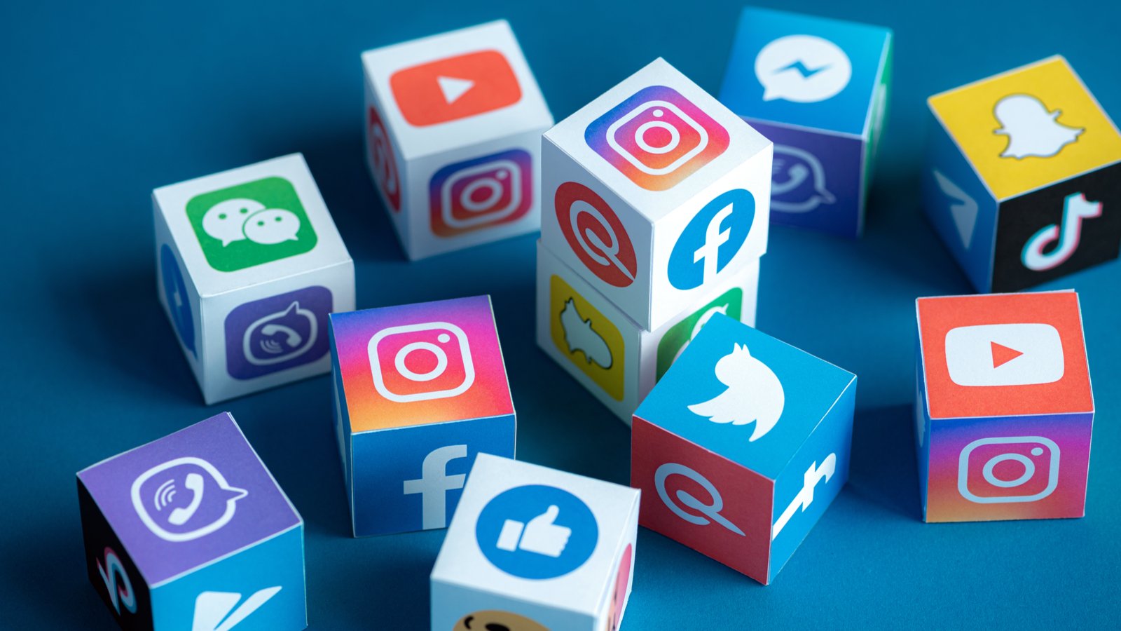 An image of blocks with different social media icons on them; Instagram, Snapchat, Twitter, YouTube, Facebook; SNAP, META, TWTR. Social Media Stock Picks for 2023