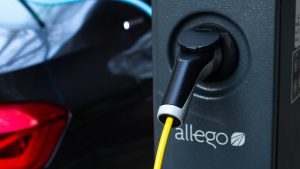 A close-up shot of an electric vehicle plugged into an Allego (ALLG) charger.