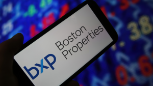 Closeup of mobile phone screen with logo lettering of boston properties, stock market chart background. BXP stock.